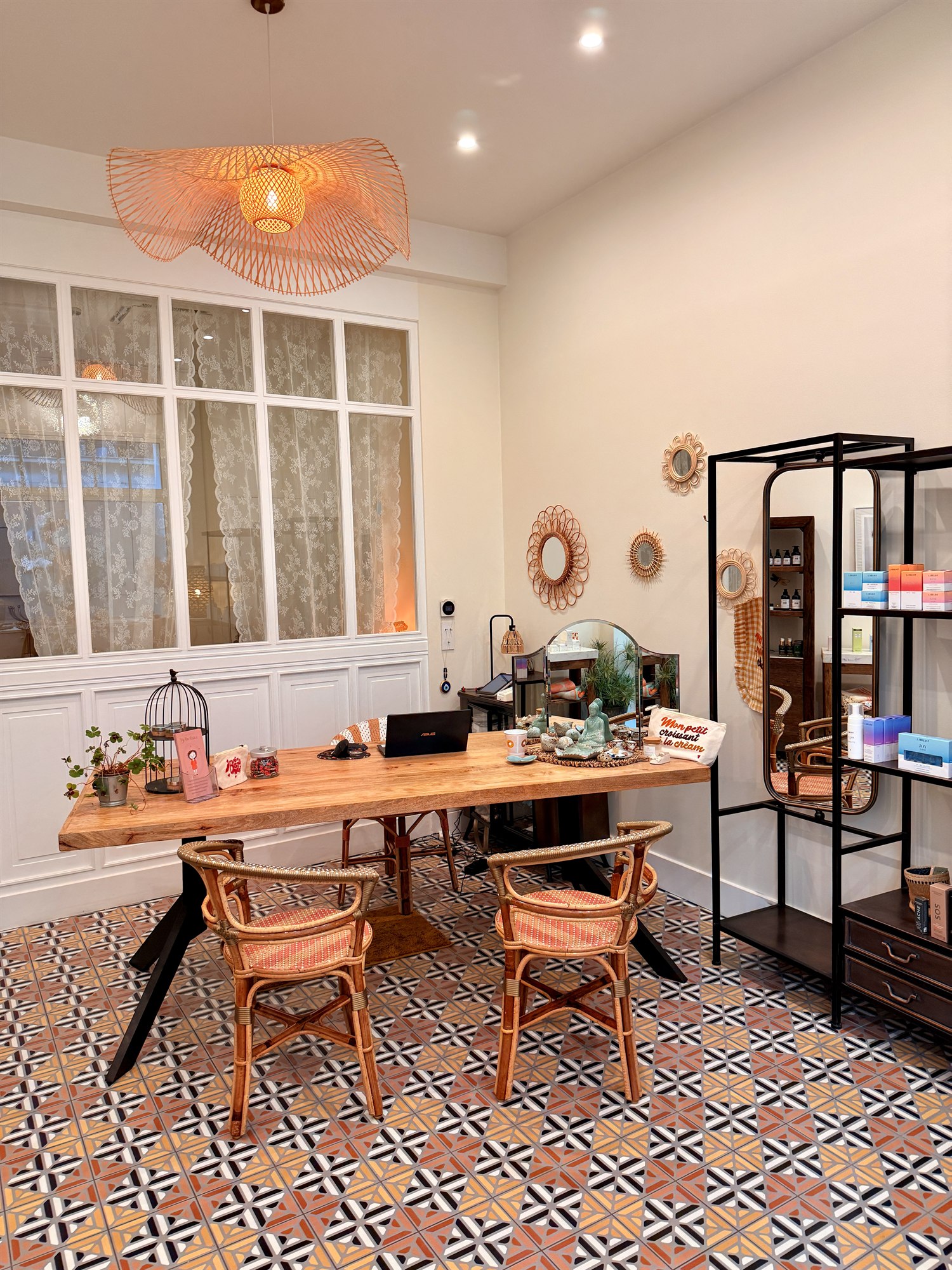 La pièce d'accueil : table en bois, chaises en rotin, verrière et carreaux de ciment